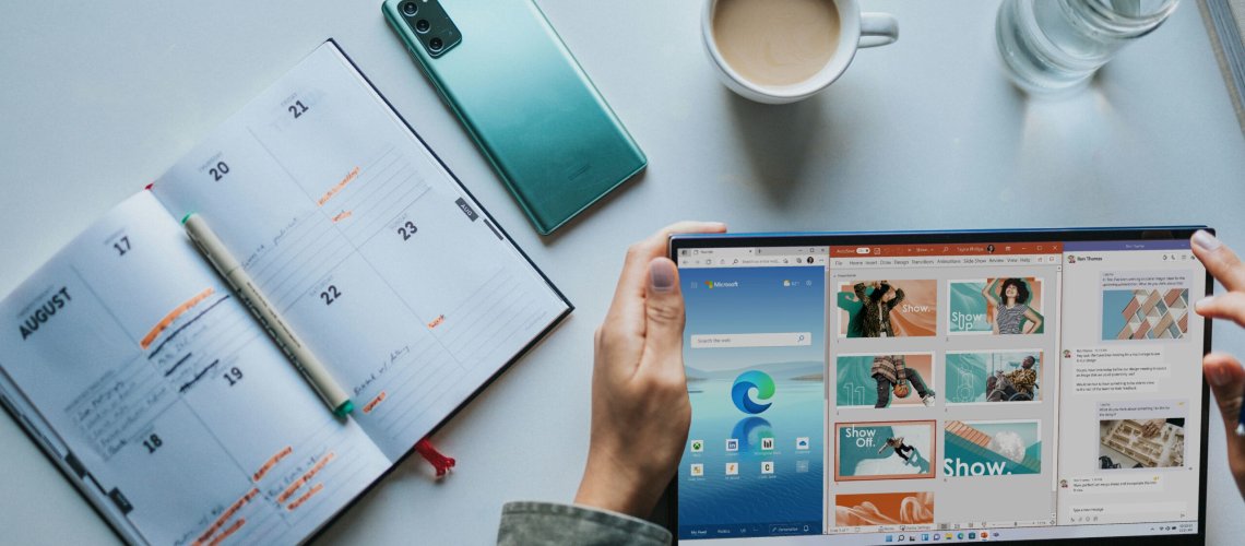 person using Windows 11 computer beside white ceramic mug on white table, Microsoft 365 Apps