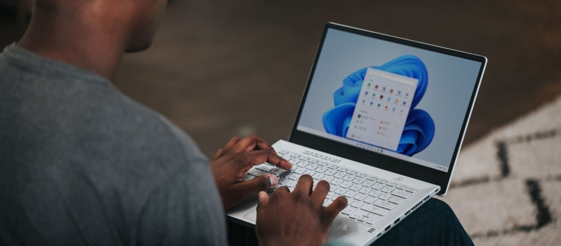 man in gray long sleeve shirt using Windows 11 computer for Data Visualization Reports.